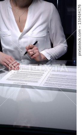 Businesswoman signing a contract late in the office, closing a deal, or completing legal paperwork at deep night. Audit and overworking concepts 138484176