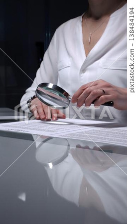 Woman analyzing contract text with magnifying glass, scrutinizing fine print for legal details and agreement review. Audit, business and overworking concepts Woman analyzing contract text with magnifying glass, scrutinizing fine print for legal details and agreement review. Audit, business and overworking concepts 138484194