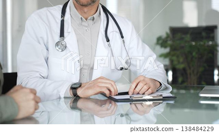Doctor and patient discussing medical diagnosis, providing healthcare advice during consultation in clinic office. Medicine, health care and science concept 138484229