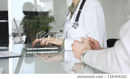 Doctor woman typing on laptop during medical consultation with patient, discussing healthcare technology and modern diagnostics. Medicine, health care and science concept Doctor woman typing on laptop during medical consultation with patient, discussing healthcare technology and modern diagnostics. Medicine, health care and science concept 138484262