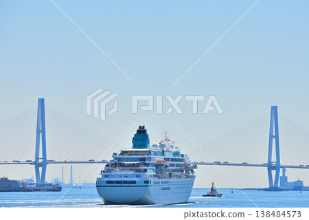 A luxury cruise ship and tugboat sailing towards the Meiko Triton Bridge in Nagoya Port. A luxury cruise ship and tugboat sailing towards the Meiko Triton Bridge in Nagoya Port. 138484573