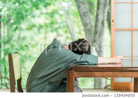 A woman in a yukata falls asleep at the table after drinking too much at a ryokan inn A woman in a yukata falls asleep at the table after drinking too much at a ryokan inn 138484850