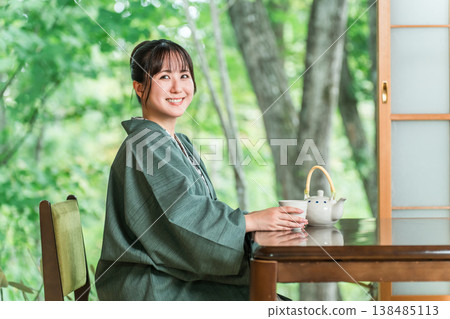 身著浴衣的亞洲年輕女子在日式旅館的房間喝茶 138485113