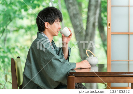 身著浴衣的亞洲年輕女子在日式旅館的房間喝茶 身著浴衣的亞洲年輕女子在日式旅館的房間喝茶 138485232