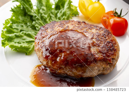A simple hamburger steak served on a white plate. A homemade-style meat dish on the table. A classic Western dish. A simple hamburger steak served on a white plate. A homemade-style meat dish on the table. A classic Western dish. 138485723