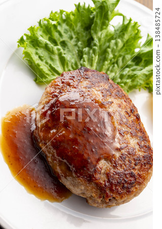 A simple hamburger steak served on a white plate. A homemade-style meat dish on the table. A classic Western dish. A simple hamburger steak served on a white plate. A homemade-style meat dish on the table. A classic Western dish. 138485724