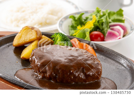 A simple hamburger steak served on a white plate. A homemade-style meat dish on the table. A classic Western dish. 138485730