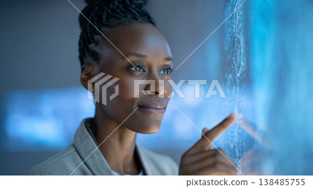 Professional female executive touching holographic interface, analyzing digital data projections within sleek corporate workspace, showcasing advanced technological interaction 138485755