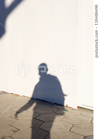 Shadow of person walking beside white wall Shadow of person walking beside white wall 138486496