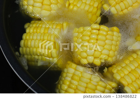 Corn pieces boiling in hot water inside a pan. Corn pieces boiling in hot water inside a pan. 138486822