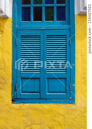 Blue wooden window on a yellow wall. Blue wooden window on a yellow wall. 138487083