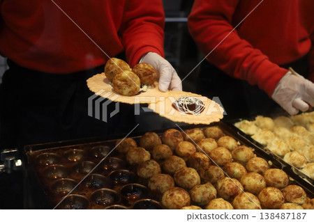 Fresh takoyaki balls being cooked on a hot iron pan at a Japanese market. Fresh takoyaki balls being cooked on a hot iron pan at a Japanese market. 138487187