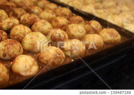 Fresh takoyaki balls being cooked on a hot iron pan at a Japanese market. Fresh takoyaki balls being cooked on a hot iron pan at a Japanese market. 138487188