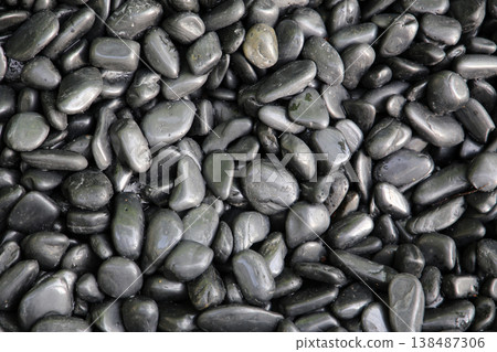 Smooth black river stones with a shiny wet surface. Smooth black river stones with a shiny wet surface. 138487306