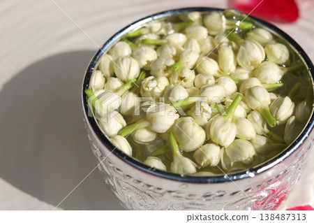 Fresh jasmine buds floating in a silver water bowl. Fresh jasmine buds floating in a silver water bowl. 138487313