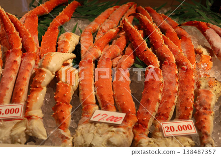 Frozen king crab legs on ice with price tags. 138487357