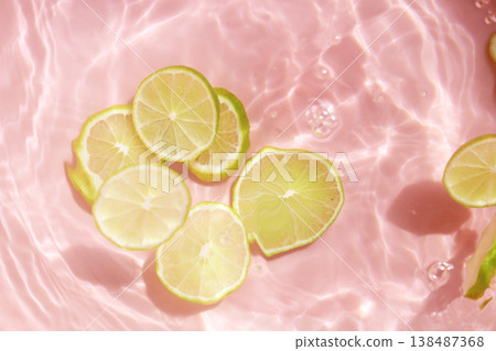 Fresh green lime slices floating in clear water with ripples texture. 138487368