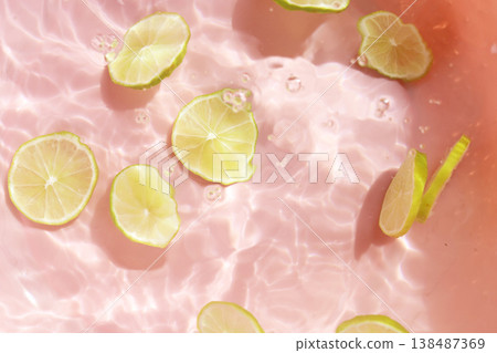 Fresh green lime slices floating in clear water with ripples texture. Fresh green lime slices floating in clear water with ripples texture. 138487369