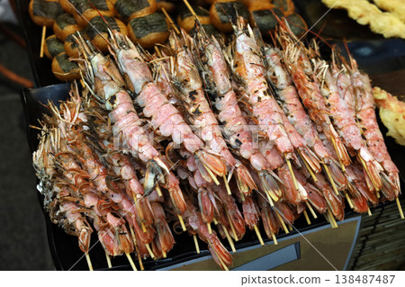 Prawns on skewers at a bustling Japanese fish market. Prawns on skewers at a bustling Japanese fish market. 138487487