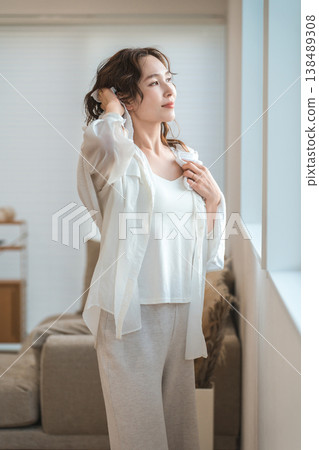 一位亞洲女性在沐浴或淋浴後用毛巾擦乾頭髮。 138489308