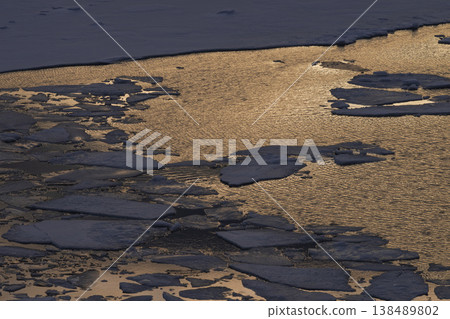 Sunset reflected in a frozen lake 138489802
