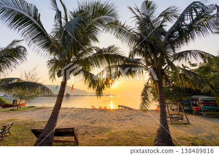 Colorful beach chairs on a peaceful sandy beach with palm trees and ocean view. Summer vacation in Thailand. 138489816