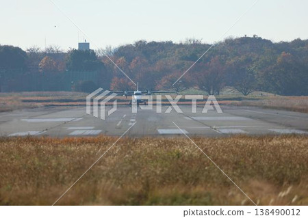 A landscape featuring airplanes: A propeller plane taking off from a runway. A landscape featuring airplanes: A propeller plane taking off from a runway. 138490012