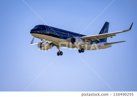 A passenger plane lands in clear weather. A passenger plane lands in clear weather. 138490295