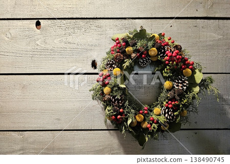 Holiday wreath made from natural dried and preserved flowers, berries, and pine cones on rustic wooden wall for chrismas. Holiday wreath made from natural dried and preserved flowers, berries, and pine cones on rustic wooden wall for chrismas. 138490745