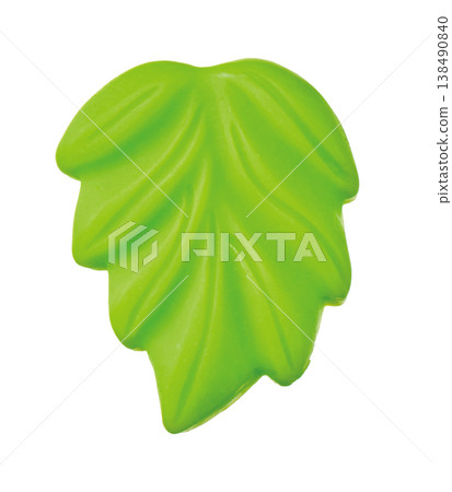 Bright green plastic leaf pieces cut out against a white background. 138490840