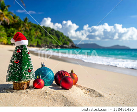 Miniature Christmas tree with santa hat and colorful ornaments on tropical beach sand with turquoise ocean and palm trees for holiday vacation and exotic celebration concepts 138491480