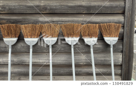 A broom leaning against a wall A broom leaning against a wall 138491829
