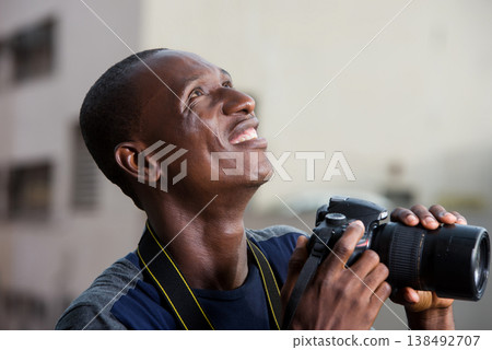 close up of young man with camera, smiling. close up of young man with camera, smiling. 138492707