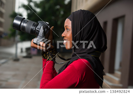close-up of young muslim woman with camera, smiling. close-up of young muslim woman with camera, smiling. 138492824