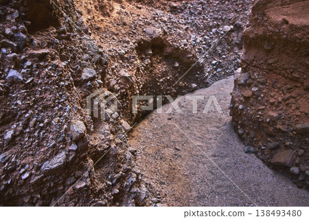 Winding Sandy Path and Rocky Walls in a Narrow Slot Canyon with Warm Light Winding Sandy Path and Rocky Walls in a Narrow Slot Canyon with Warm Light 138493480