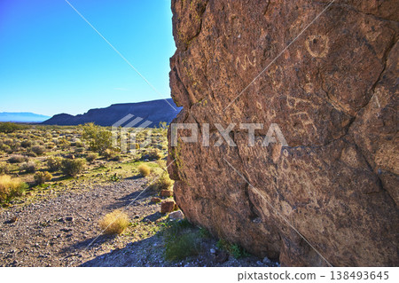 Petroglyph Rock Face and Mojave Desert Landscape Under Bright California Sky Petroglyph Rock Face and Mojave Desert Landscape Under Bright California Sky 138493645