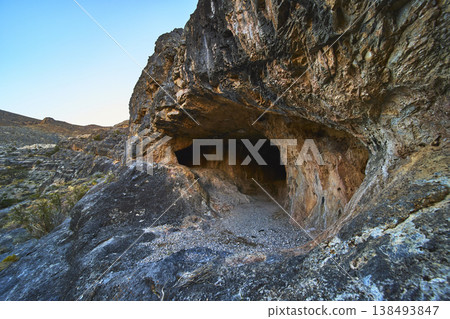 Cave Entrance in Rugged Desert Rock Formation and Arid Landscape Nevada Cave Entrance in Rugged Desert Rock Formation and Arid Landscape Nevada 138493847