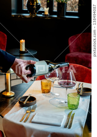 Celebration table with drinks and decor. Guests enjoy wine amidst warm seasonal decorations Celebration table with drinks and decor. Guests enjoy wine amidst warm seasonal decorations 138494087