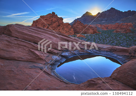 Golden Hour Sunrise Over Redstone Dune With Desert Tinaja And Reflective Water Basin Golden Hour Sunrise Over Redstone Dune With Desert Tinaja And Reflective Water Basin 138494112
