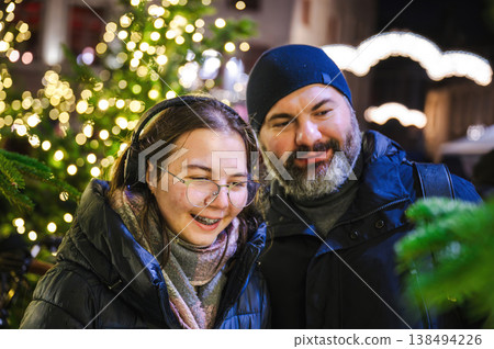 Cheerful Christmas Girl with Her Father and Festive Lights Cheerful Christmas Girl with Her Father and Festive Lights 138494226