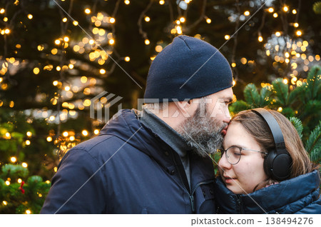 Cheerful Christmas Girl with Her Father and Festive Lights Cheerful Christmas Girl with Her Father and Festive Lights 138494276