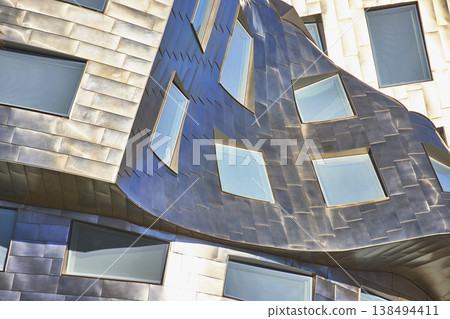 Modern Architecture Detail With Curved Metallic Facade And Geometric Windows Modern Architecture Detail With Curved Metallic Facade And Geometric Windows 138494411