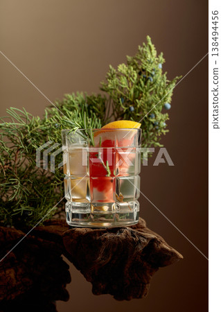 Refreshing hard seltzer with ice, grapefruit, and rosemary on an old snag. 138494456