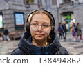 Smiling teenager girl with gallses and headphones in train staition 138494862