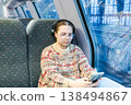 Smiling teenager girl with gallses and headphones in train 138494867