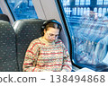 Smiling teenager girl with gallses and headphones in train 138494868