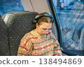 Smiling teenager girl with gallses and headphones in train 138494869