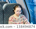Smiling teenager girl with gallses and headphones in train 138494874