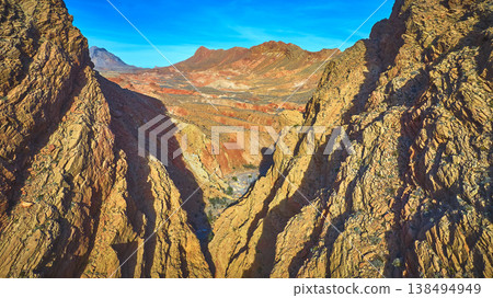 Aerial Dramatic Canyon Walls and Colorful Desert Mountains in Sunlight Aerial Dramatic Canyon Walls and Colorful Desert Mountains in Sunlight 138494949