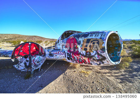 Graffiti Covered Abandoned Airplane Fuselage in Nevada Desert Under Clear Blue Sky Graffiti Covered Abandoned Airplane Fuselage in Nevada Desert Under Clear Blue Sky 138495060